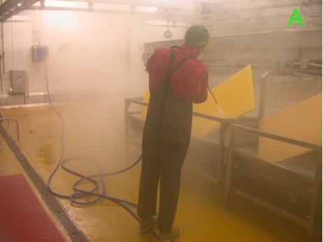 Worker using a high-pressure hose, causing vapour and aerosol