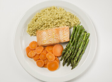 A picture of salmon with cous cous and vegetables
