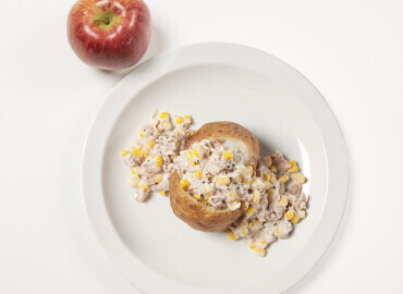 Picture showing a baked potato with sweetcorn mayonnaise and an apple