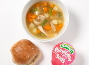 Photo of Homemade chicken and vegetable soup, a bread roll with lower fat spread, and a jelly pot