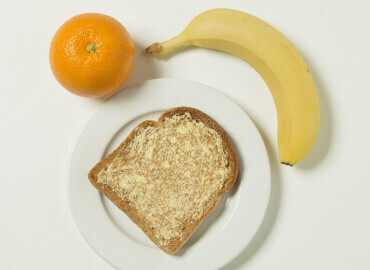 Photo of an orange, banana and a slice of toast with lower fat spread