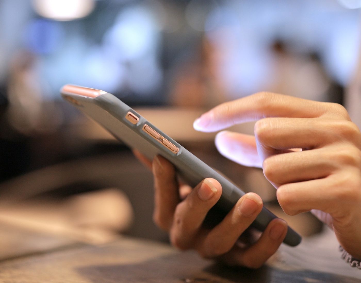 Close-up image of a younger person typing on a smartphone
