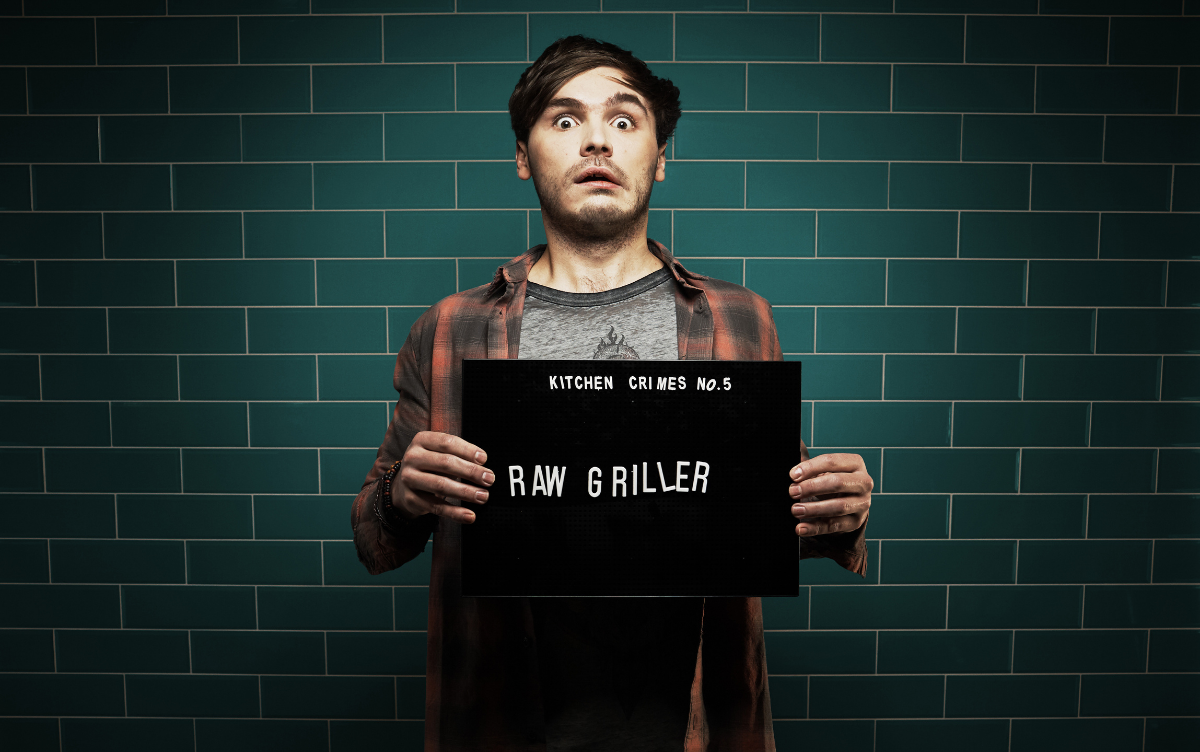 Man showing mug shot board with wording Raw Griller