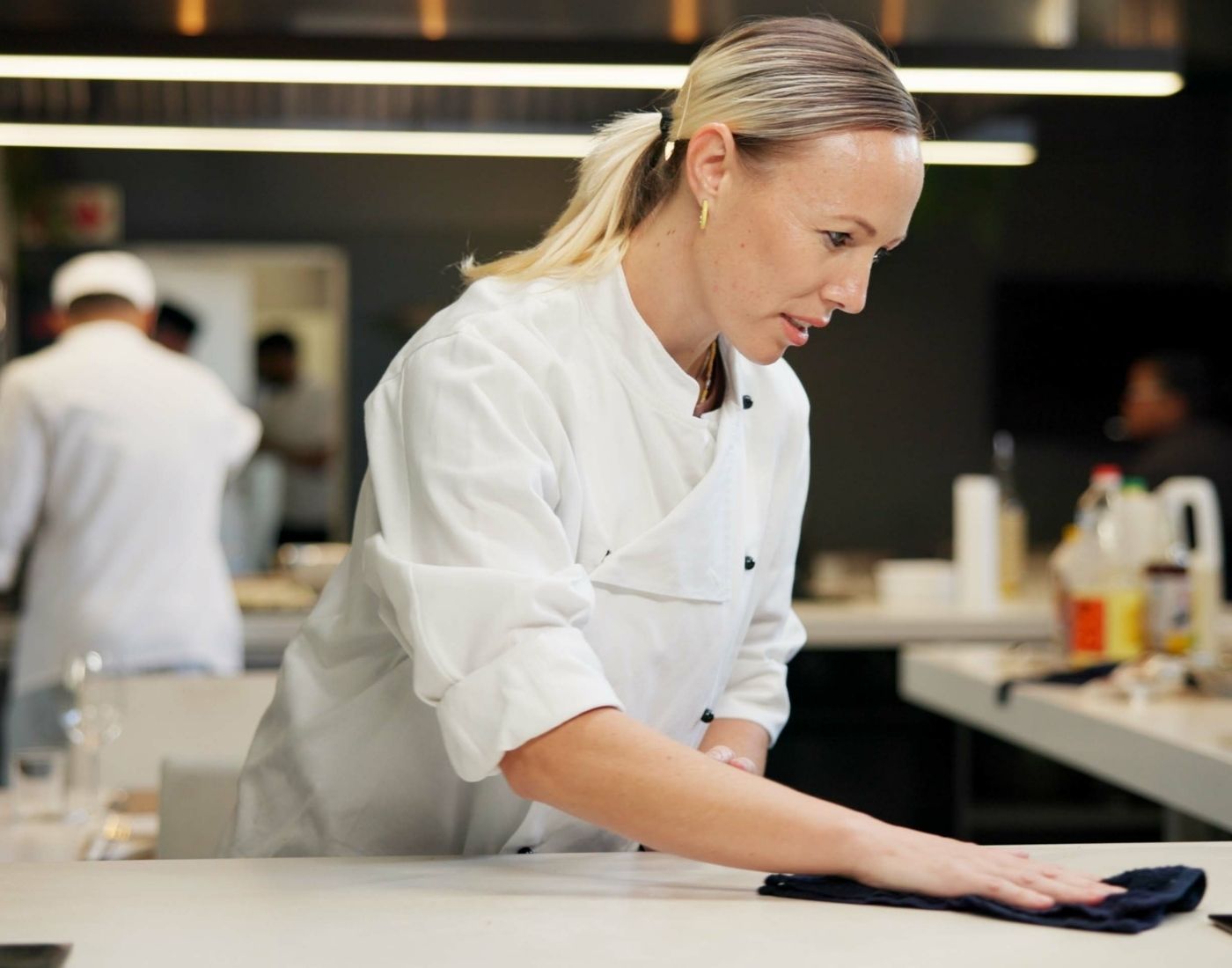 Female chef cleaning a restaurant kitchen counter
