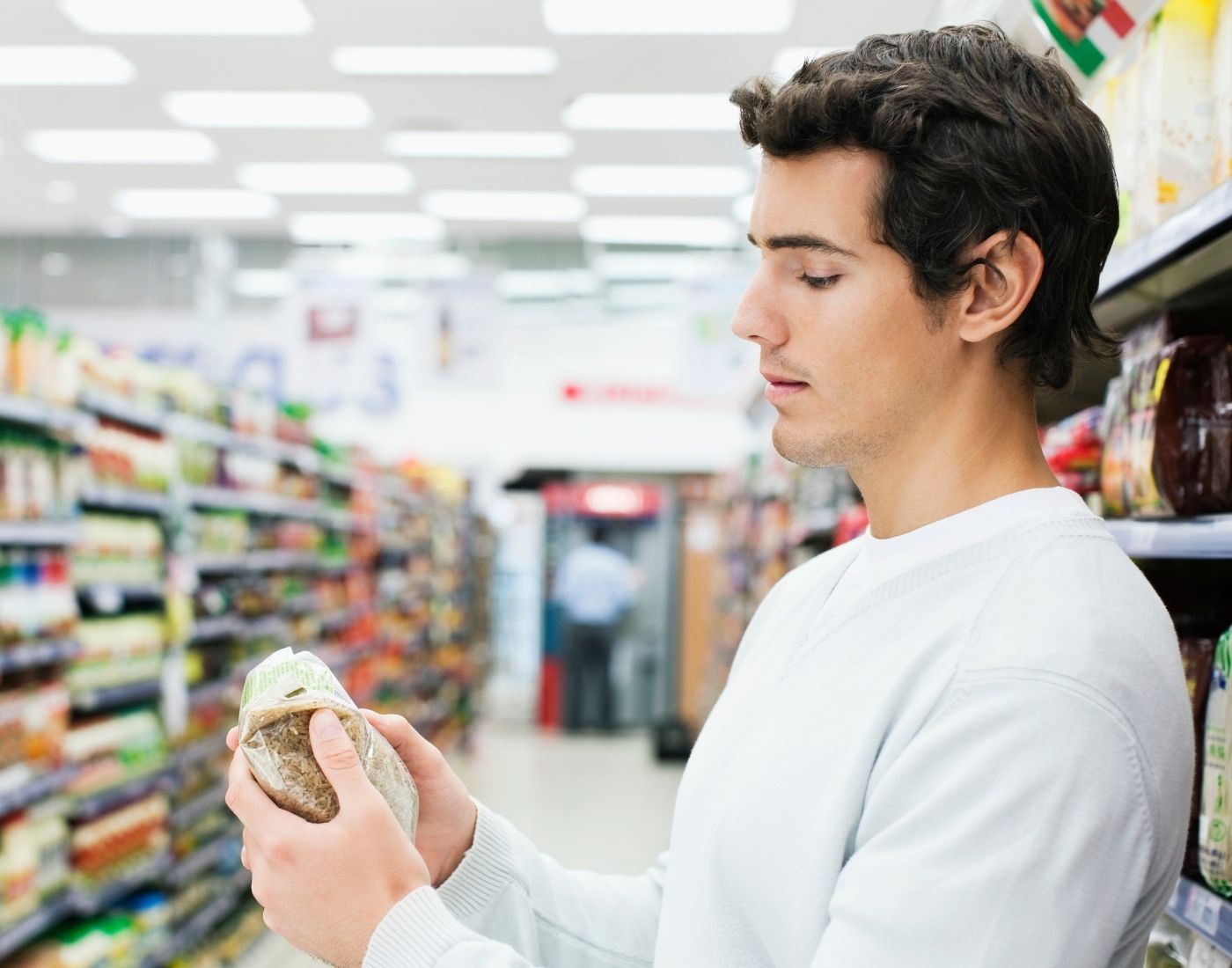 Customer reading packaging in a supermarket