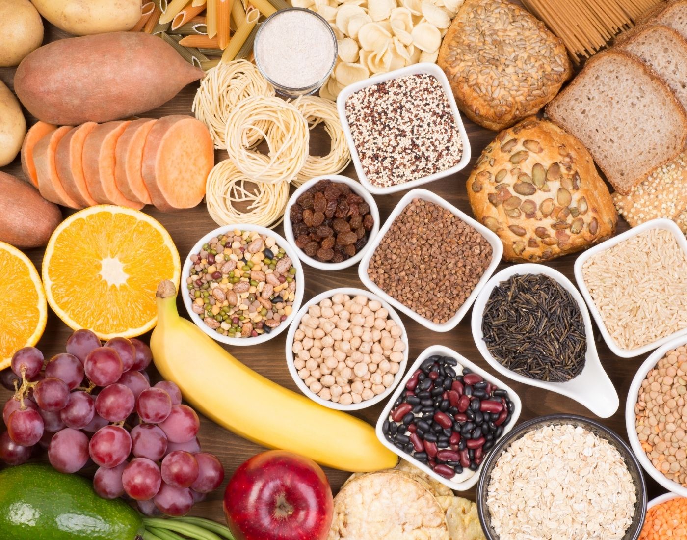A variety of healthy food items from the five food groups including fruits, vegetables, starchy foods, grains, legumes and pulses, viewed from above