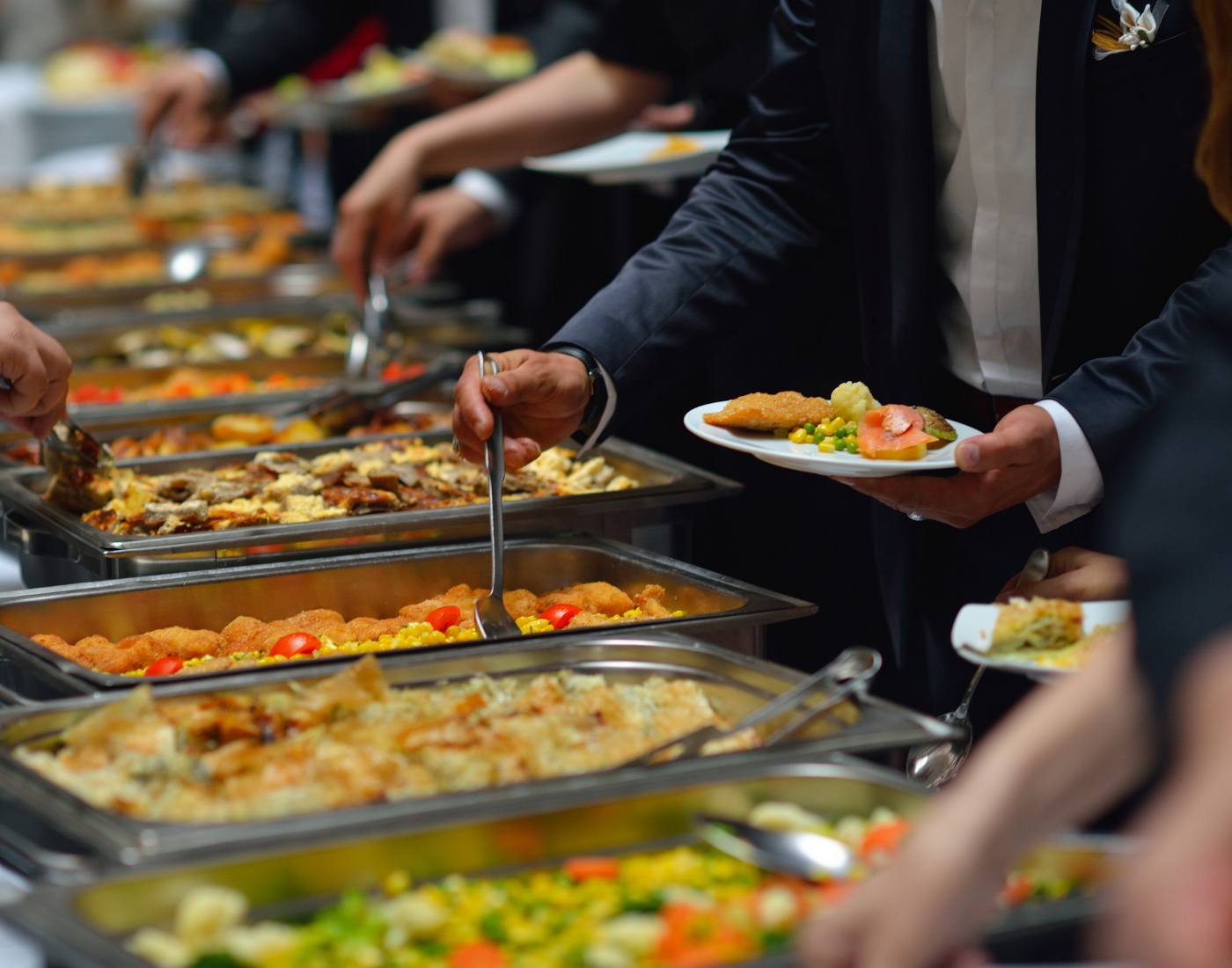 People helping themselves to buffet food provided by a caterer
