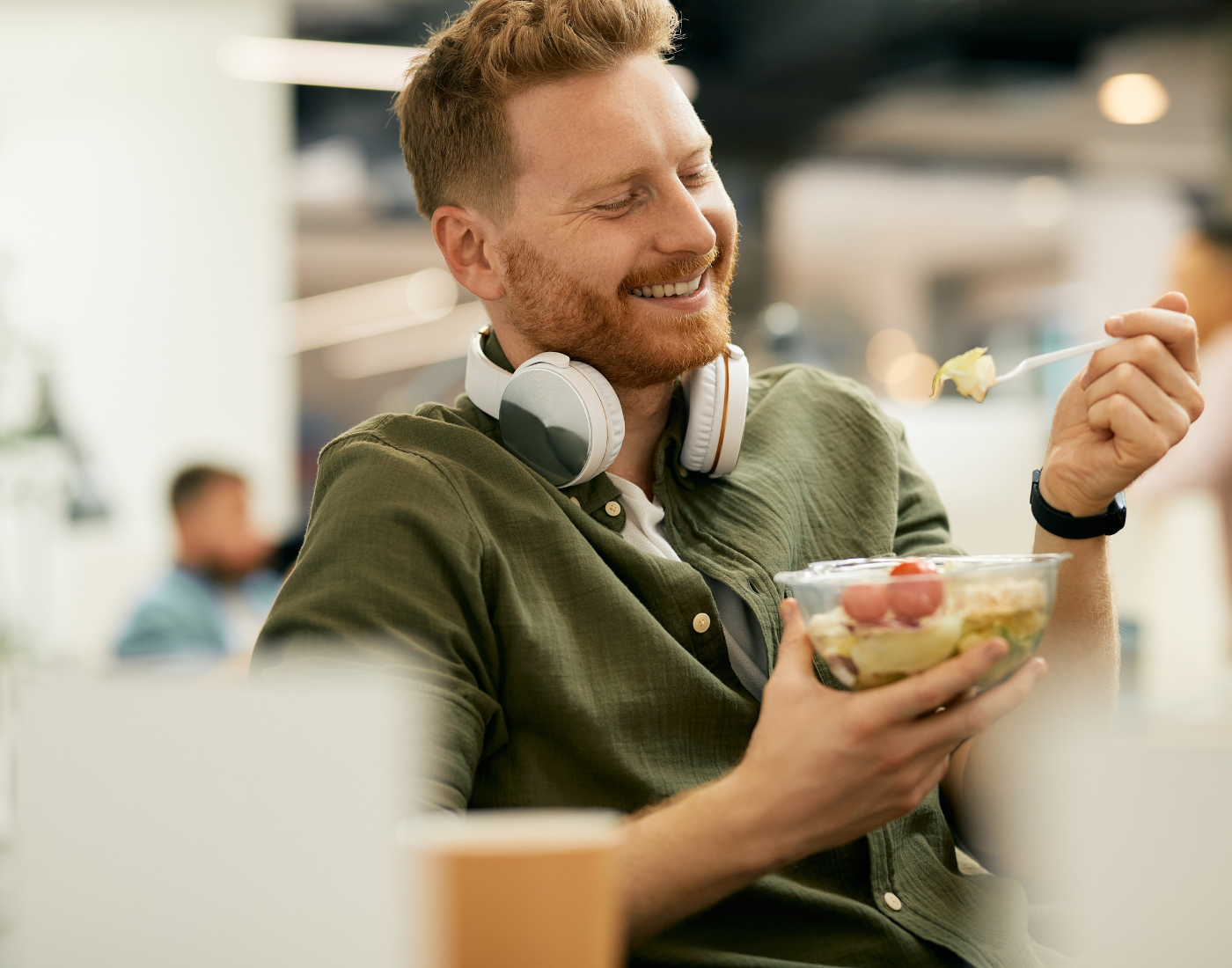 Man eating a pre-packed salad in an office