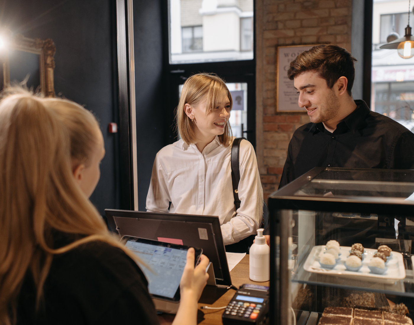 Couple ordering food in cafe with a serving assistant