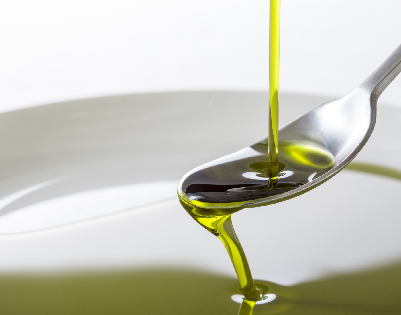Hemp oil is poured onto a spoon before falling into a bowl