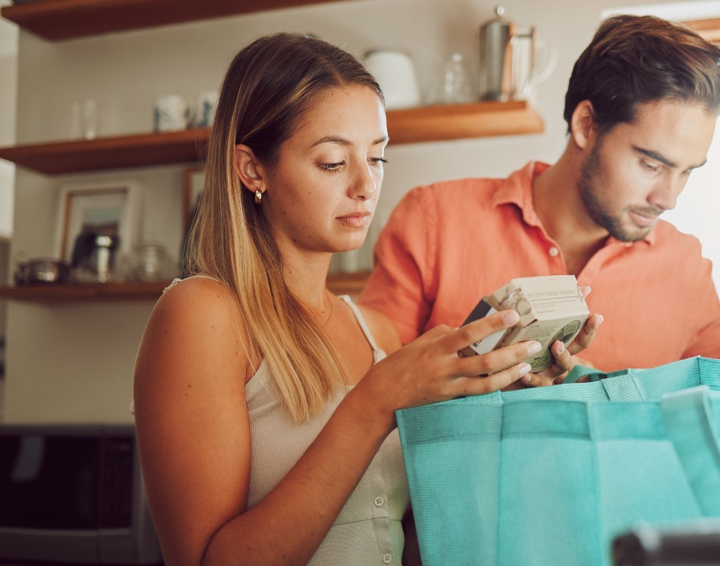 Young woman checking the food label on a small box of food.