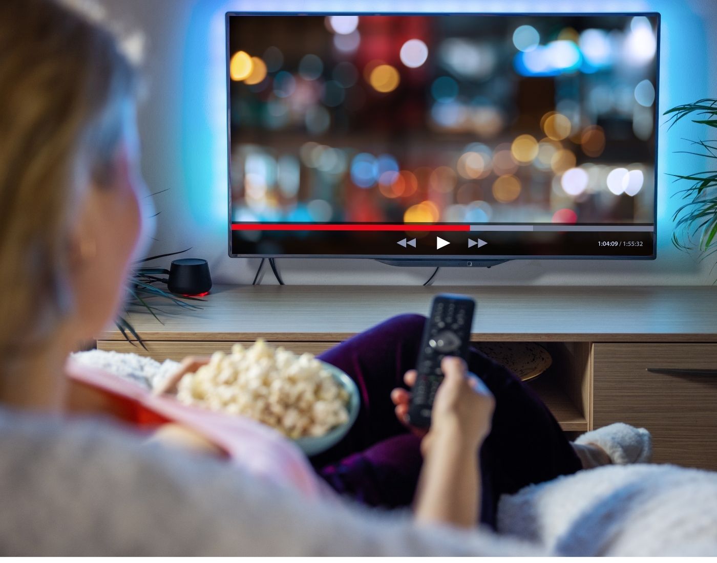 Woman eating healthy snack of plain popcorn while watching TV