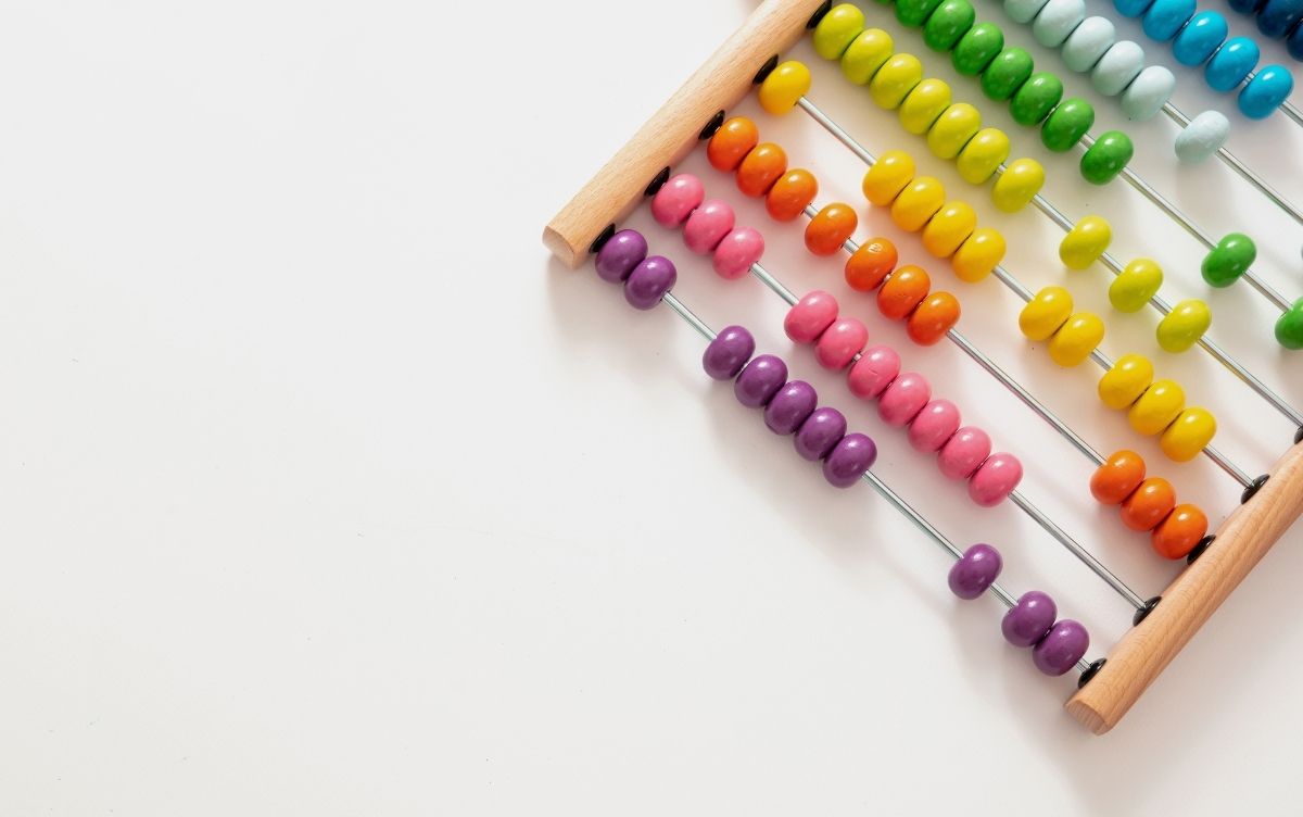 A colorful abacus with rows of beads in purple, yellow, green, and red on a white background.