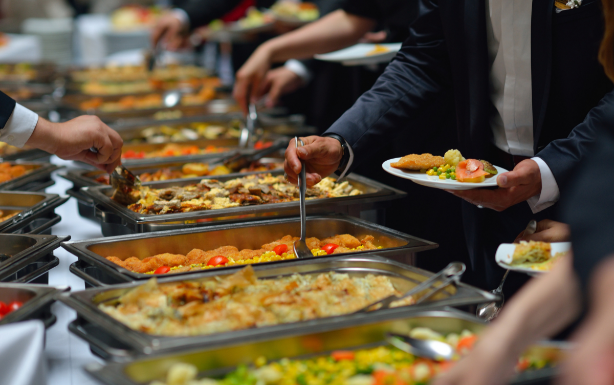 people helping themselves to buffet food