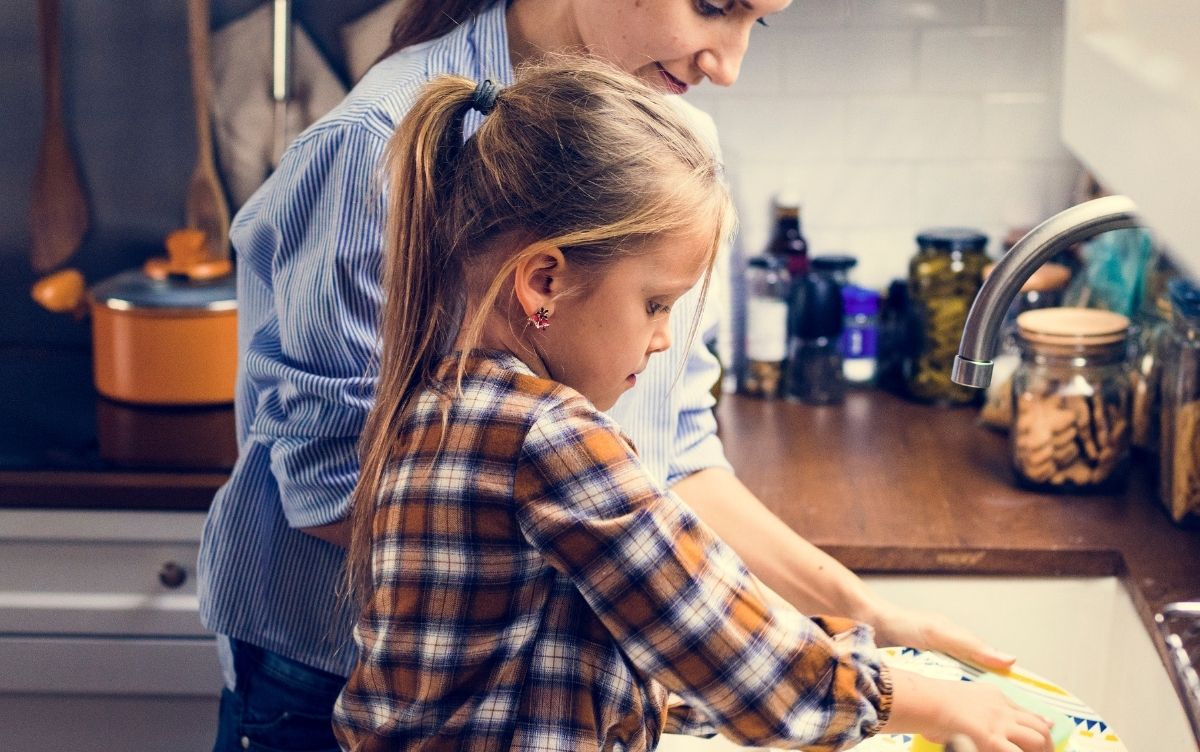 mum and daughter washing dishes at a sink