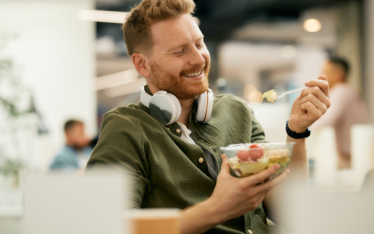 man eating prepacked salad at work