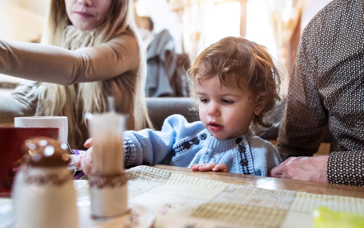 Mum, dad and toddler sitting at a restaurant table.