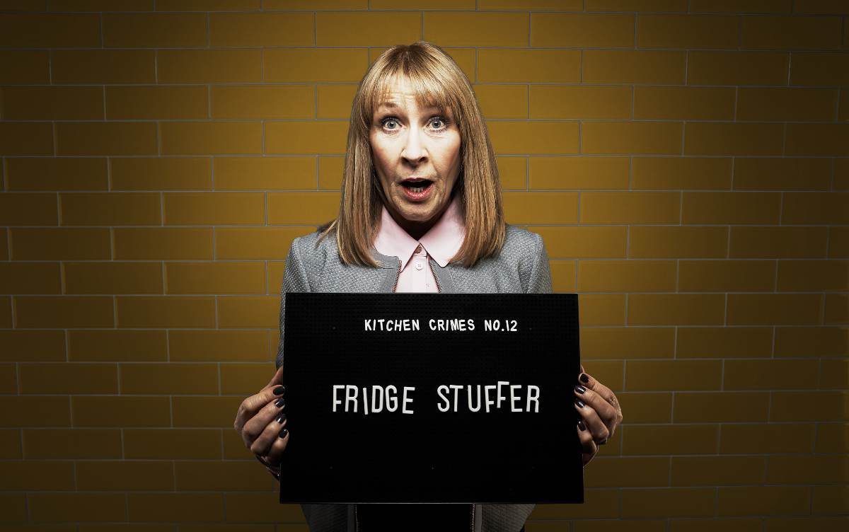 Woman holding mug shot board with words Fridge Stuffer