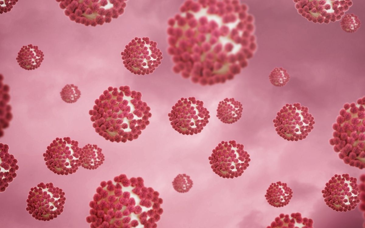 Illustration of virus particles against a pink background.