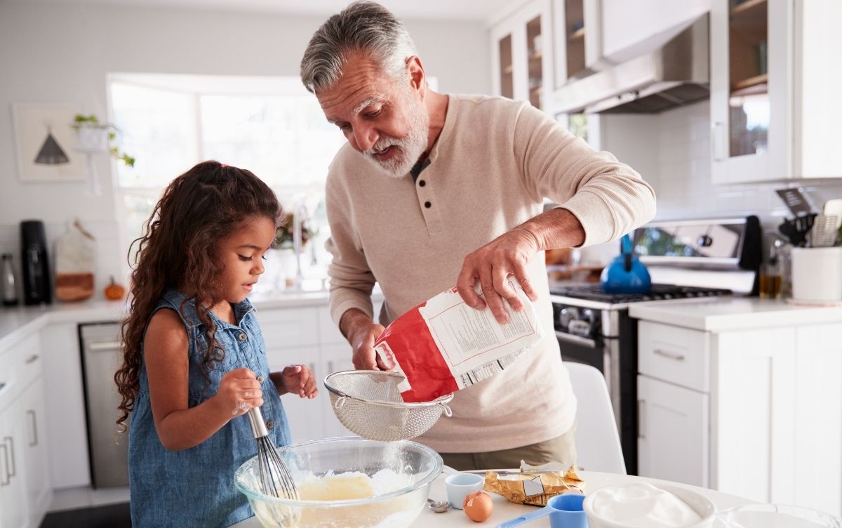 Grandfather baking with his granddaughter in the kitchen