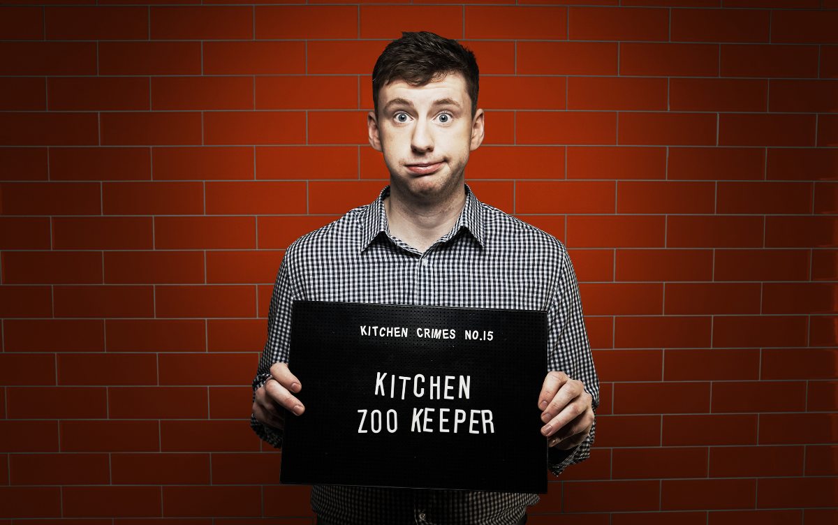 Man holding mug shot board with words Woman holding mug shot board with words Kitchen Zookeeper