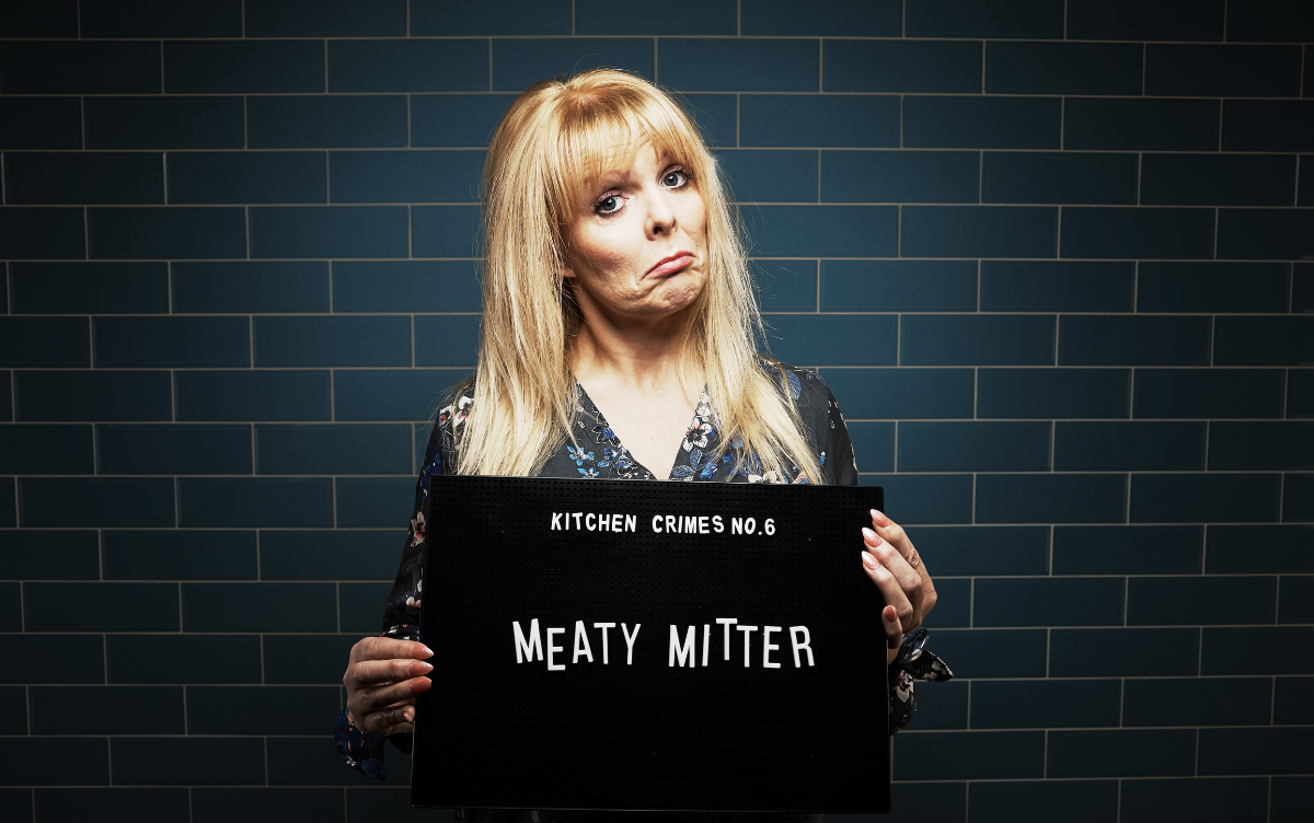 Woman holding mug shot board with words Meaty Mitter
