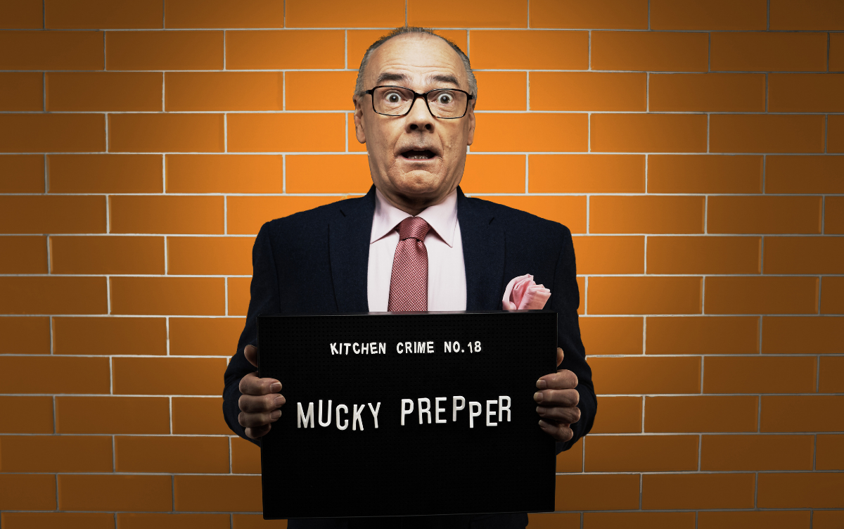 Man holding mug shot board with words Mucky Prepper