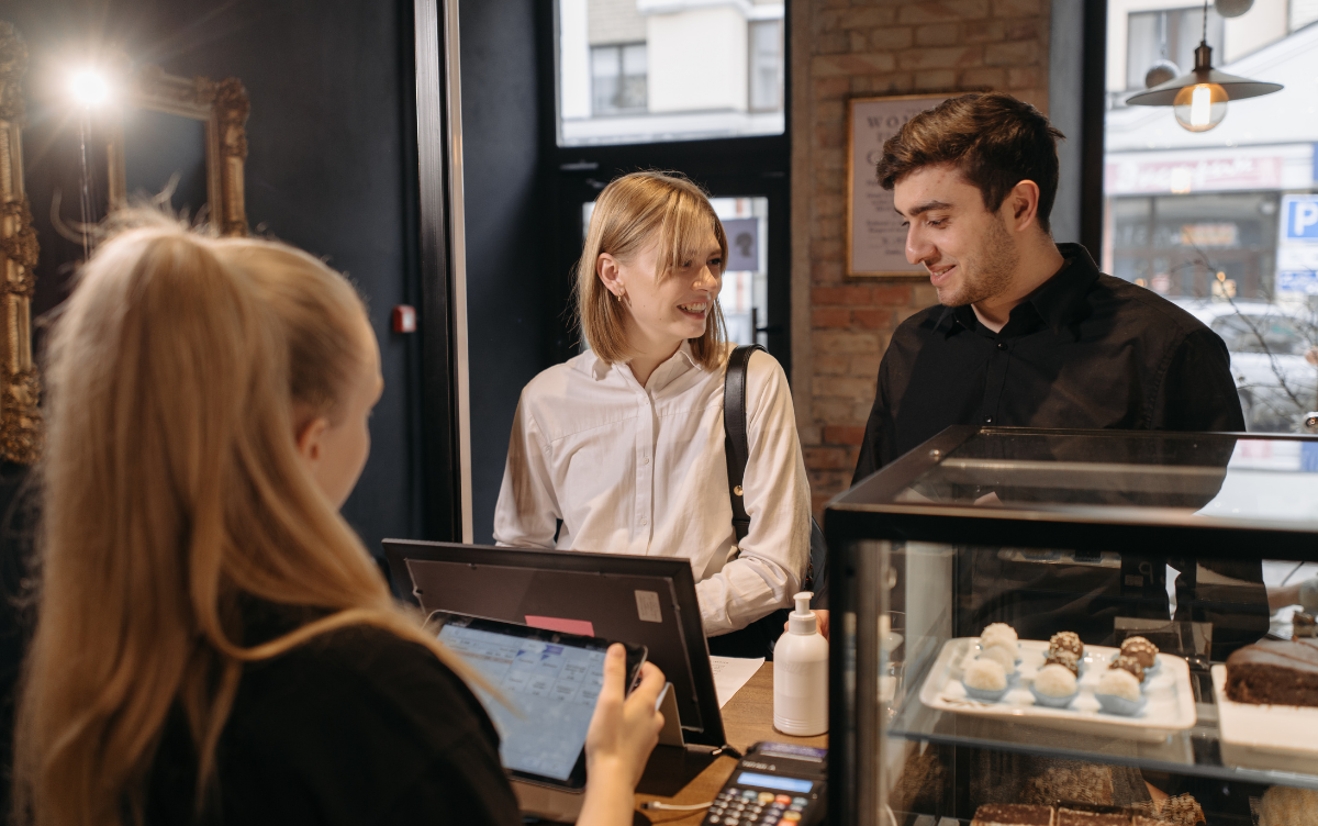 Couple ordering food in cafe with a serving assistant