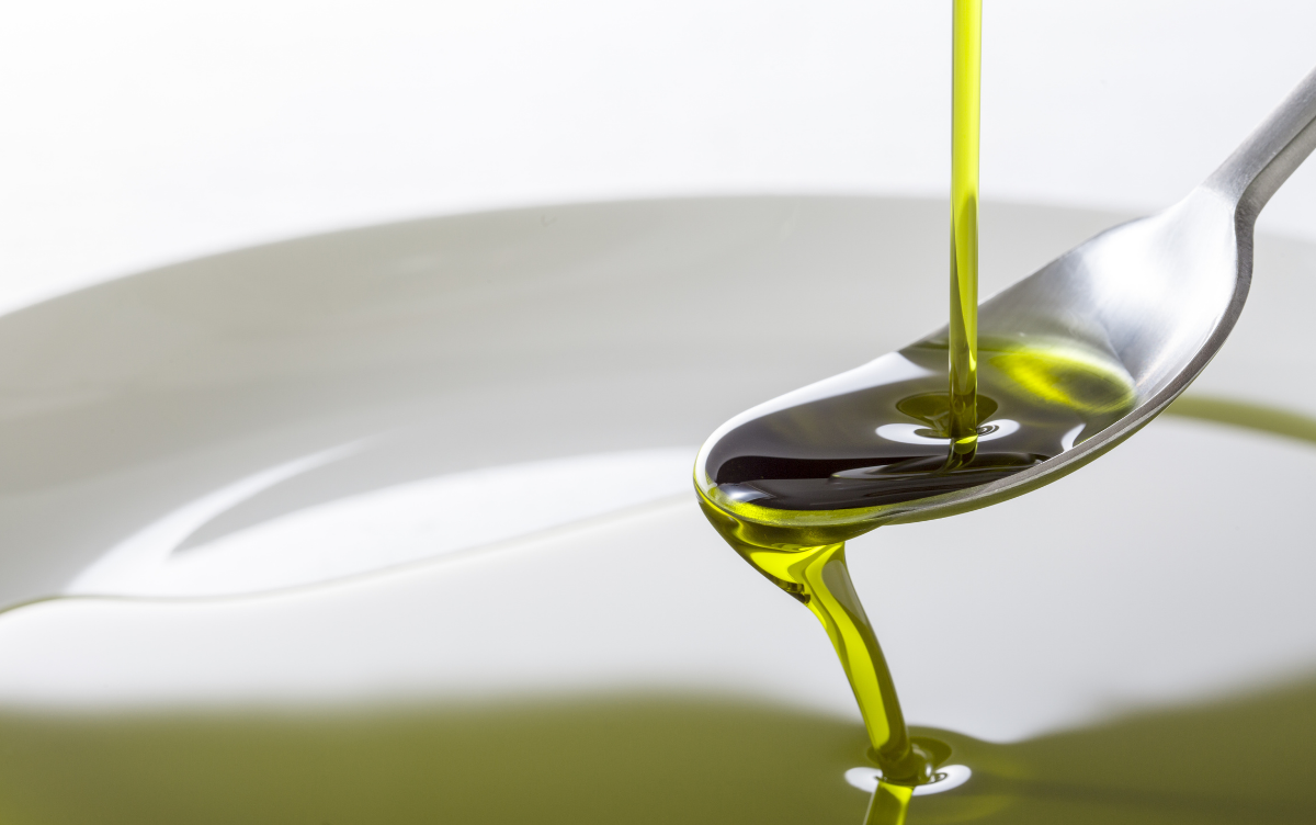 Hemp oil being poured onto a spoon before falling off spoon into a bowl