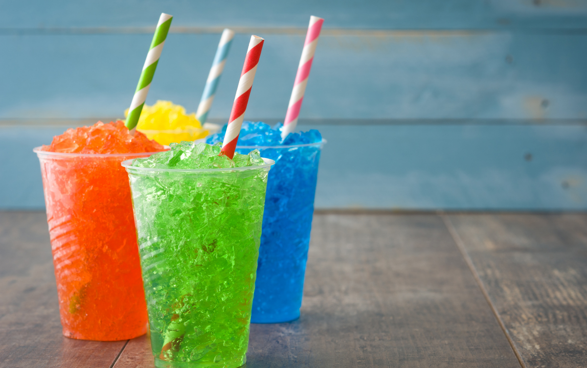 bright coloured slush drinks in cups with a straw