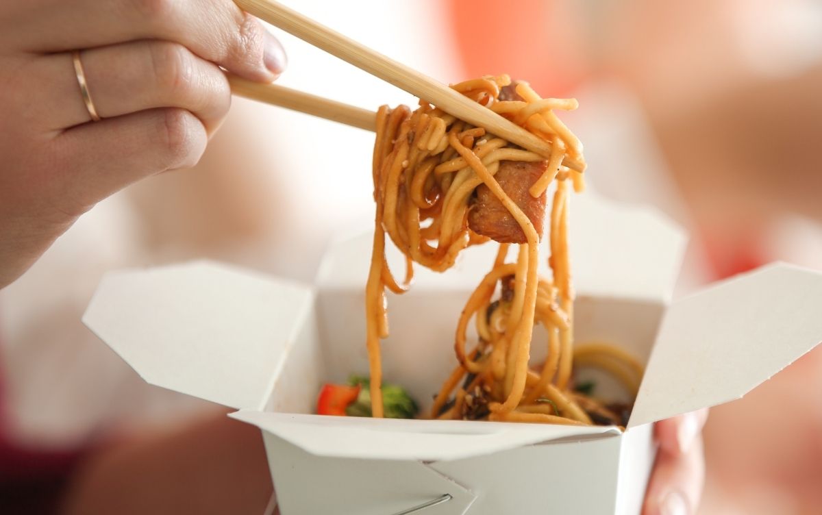 Woman's hand holding chopsticks and noodles