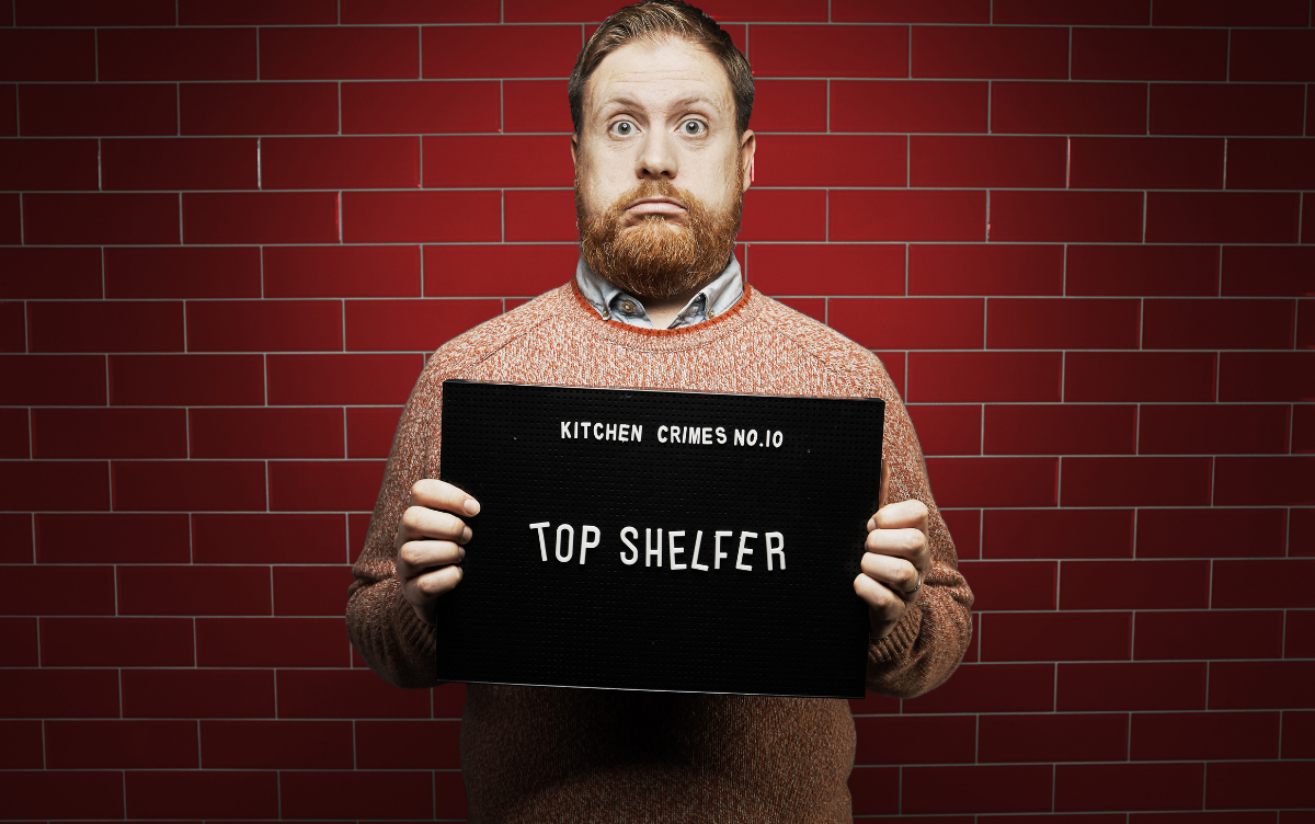 Woman holding mug shot board with words Top Shelfer