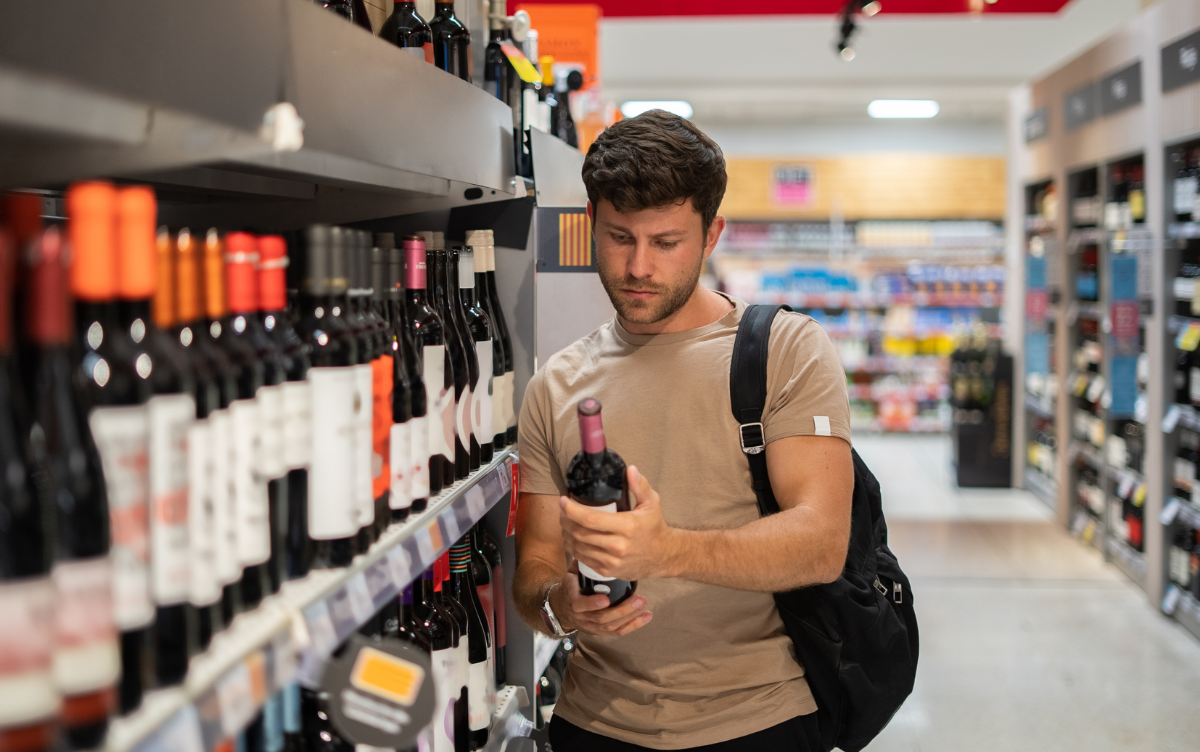 Man shopping for wine in a supermarket