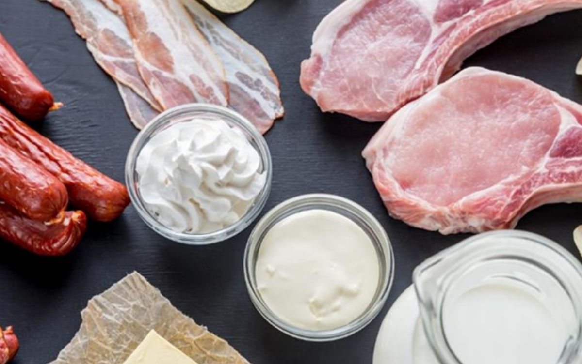 Raw meat and dairy products laid on a black surface