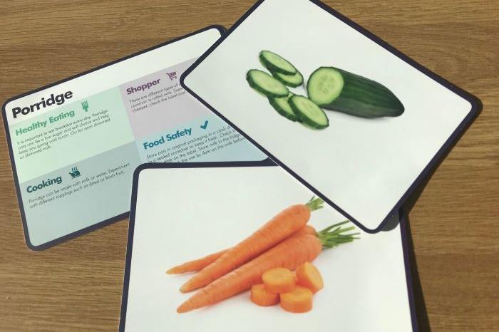 Three cards placed on a desk. One displays cucumber, one displays carrots and the other has the word porridge on it.