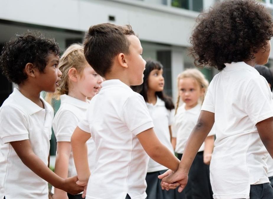 Primary school aged children holding hands and playing