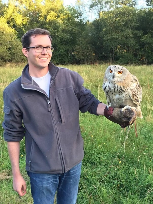 Seth Burdick smiling holding an owl.